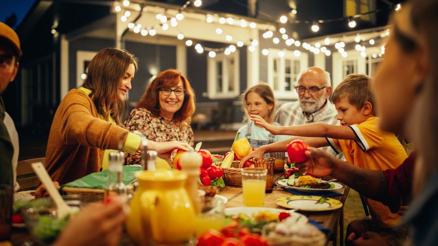 A family enjoys a meal under the stars on an outdoor patio.