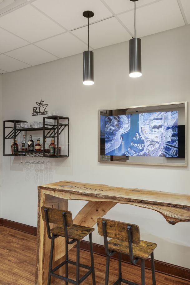 Bar area with hanging lights, wall-mounted bar shelf, and mirror TV