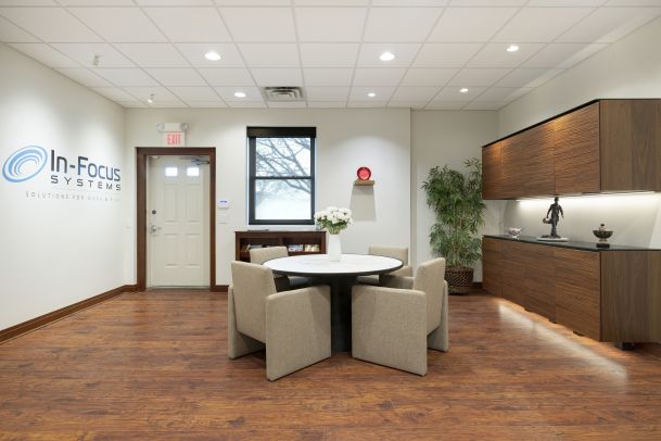Modern showroom seating area with round table and cabinetry