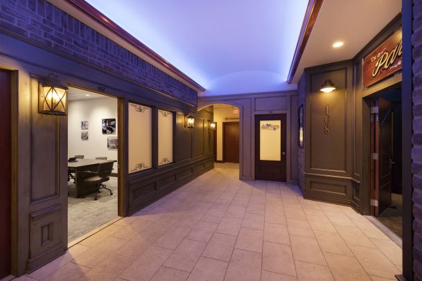 Hallway with blue accent ceiling lighting and meeting room entrances