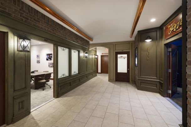 Showroom hallway with storefront-style panels and sconces
